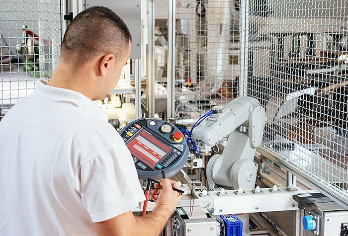 Industrial robots operate behind safety barriers.
