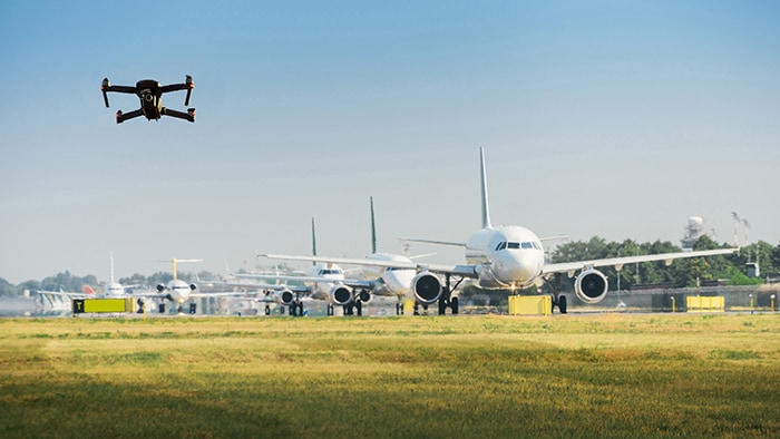 Unmanned drone flying near airplanes in airport